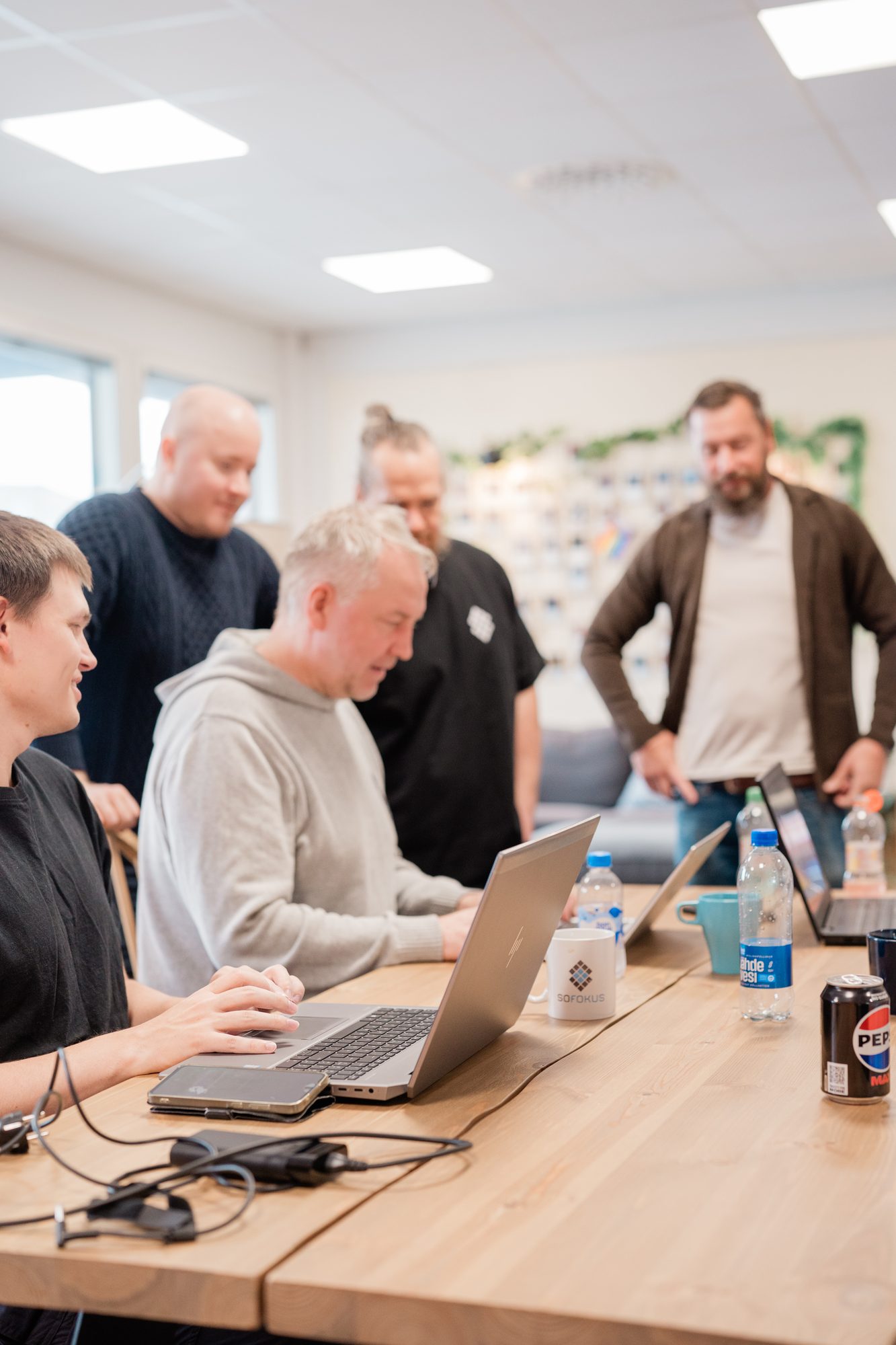 Kollegat katsovat samaa näyttöä valoisassa toimistossa.