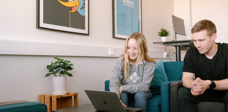 Mies mustassa T-paidassa nojaa eteenpäin ja seuraa läppärin näyttöä yhdessä toisen kanssa – Ketterä kehitys: Sofokus kehittämässä korkeakouluopintoja