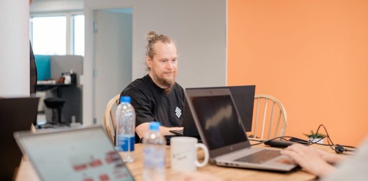 Laptops, water bottles and a white mug on a shared wooden table – Customer-centric development: 5 tips for creating an engaging website
