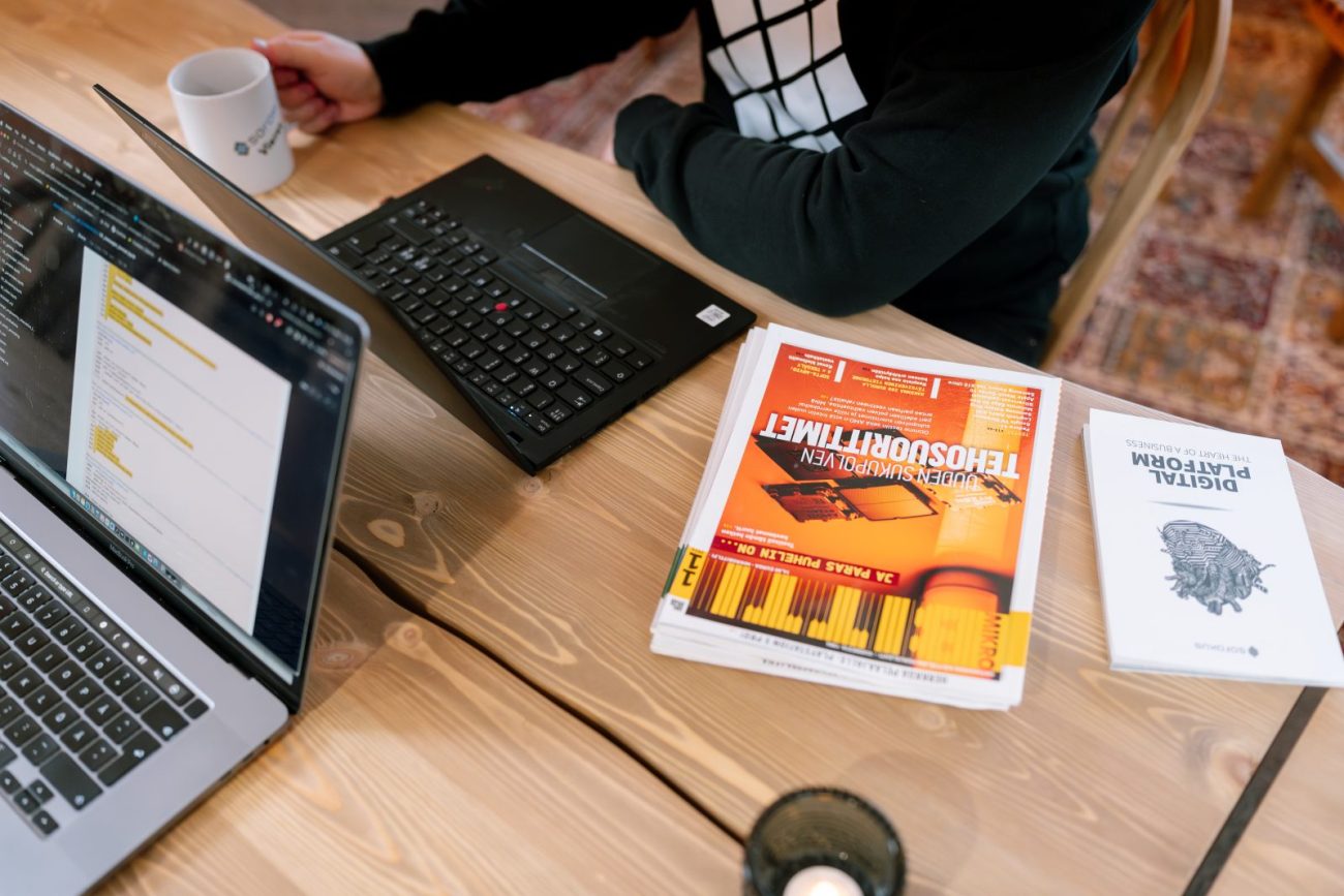 A Sofokus designer working at a desk with laptops and design materials