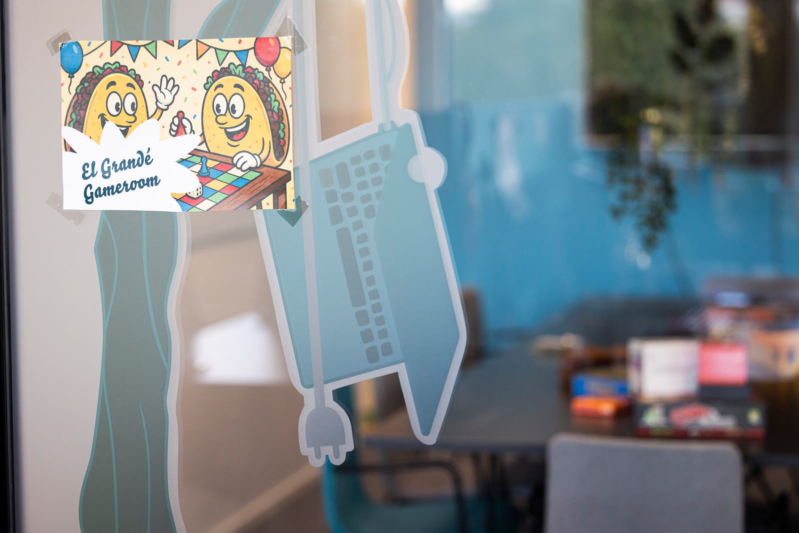 Glass door of the Sofokus office game room with playful illustrations