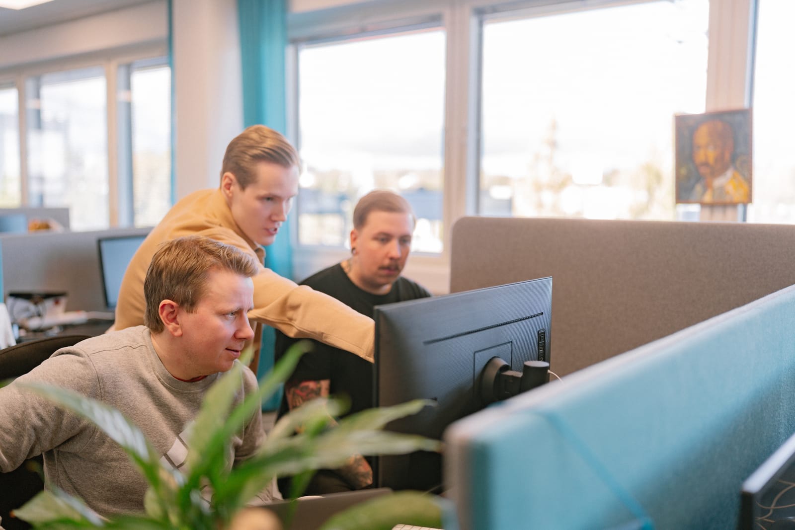 Three Sofokus developers collaborating at a monitor in the office
