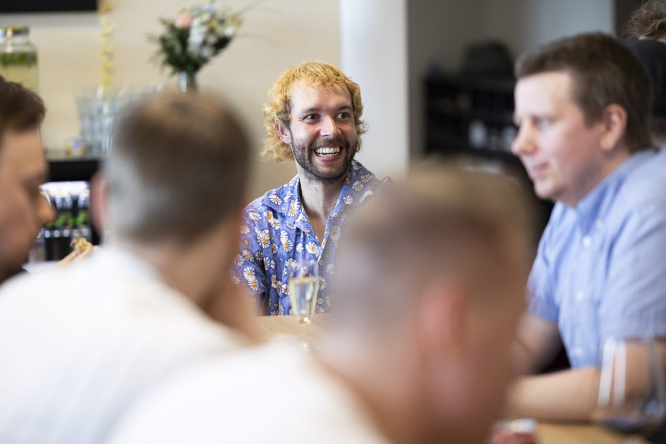 Sofokus team members chatting and laughing together around a table