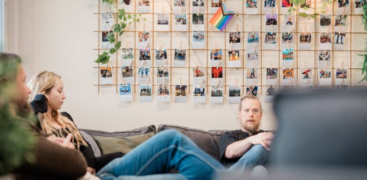 Rento keskustelu oleskelutilassa kuvattuna etualalla istuvan henkilön ohi – Työntekijäkokemus on avain asiakaskokemukseen
