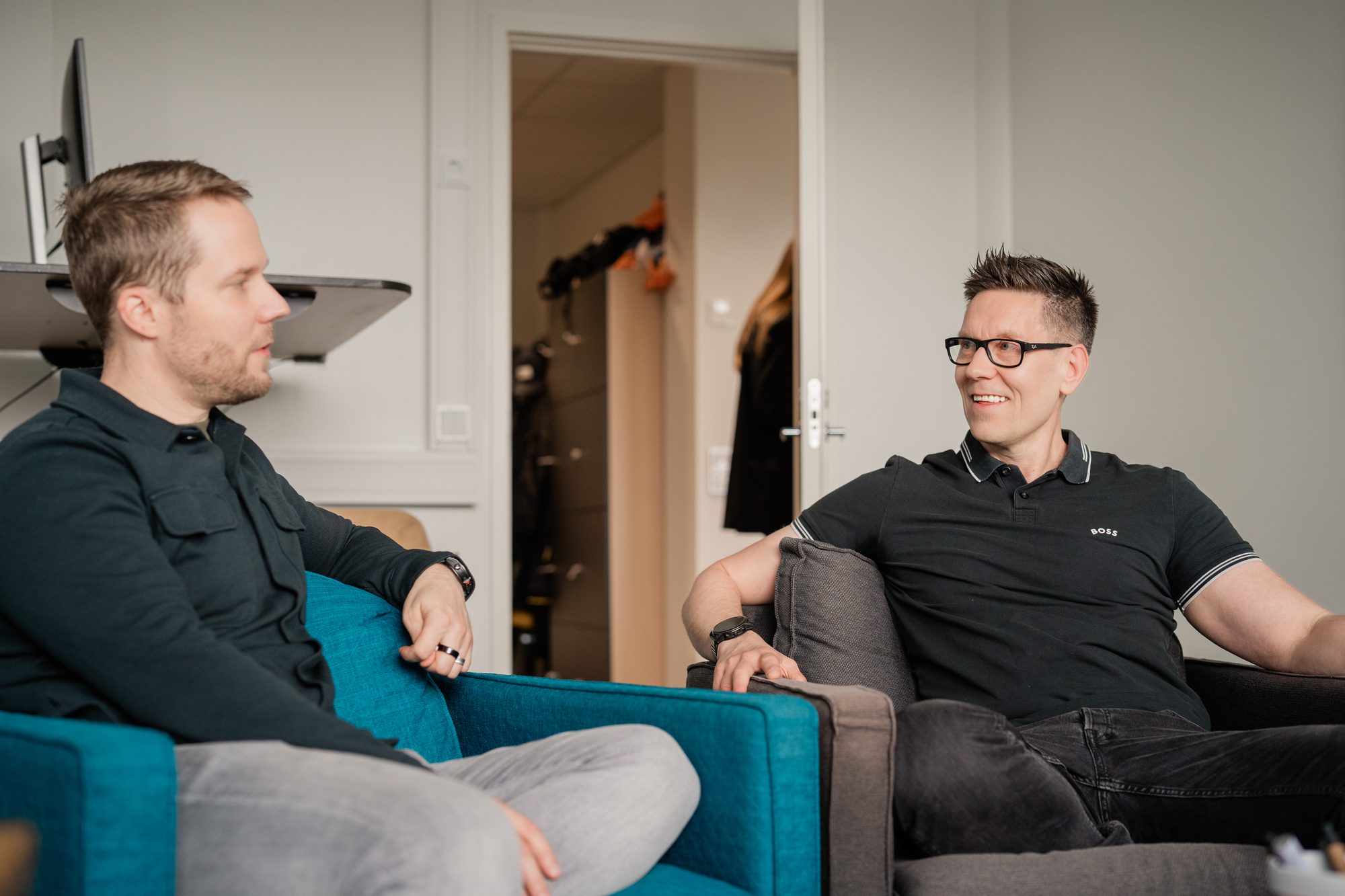 Kaksi ihmistä juttelee hymyillen nojatuoleissa – Automaatio – Eetu Paloheimo, Veikkaus
