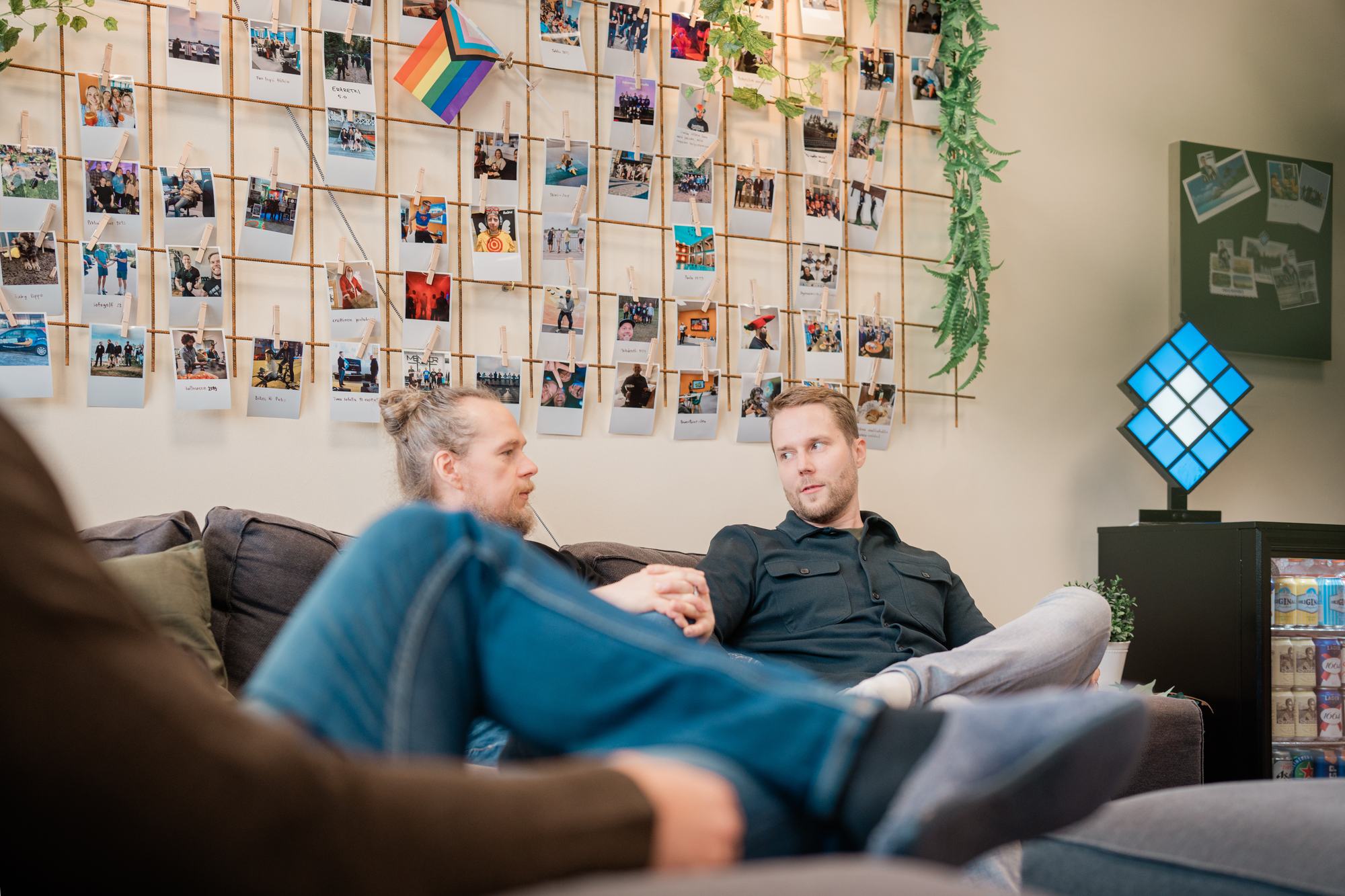 Nutturapäinen henkilö ja tummaan paitaan pukeutunut kollega istuvat sohvalla toimiston oleskelutilassa – Facebook ja verkkokauppa