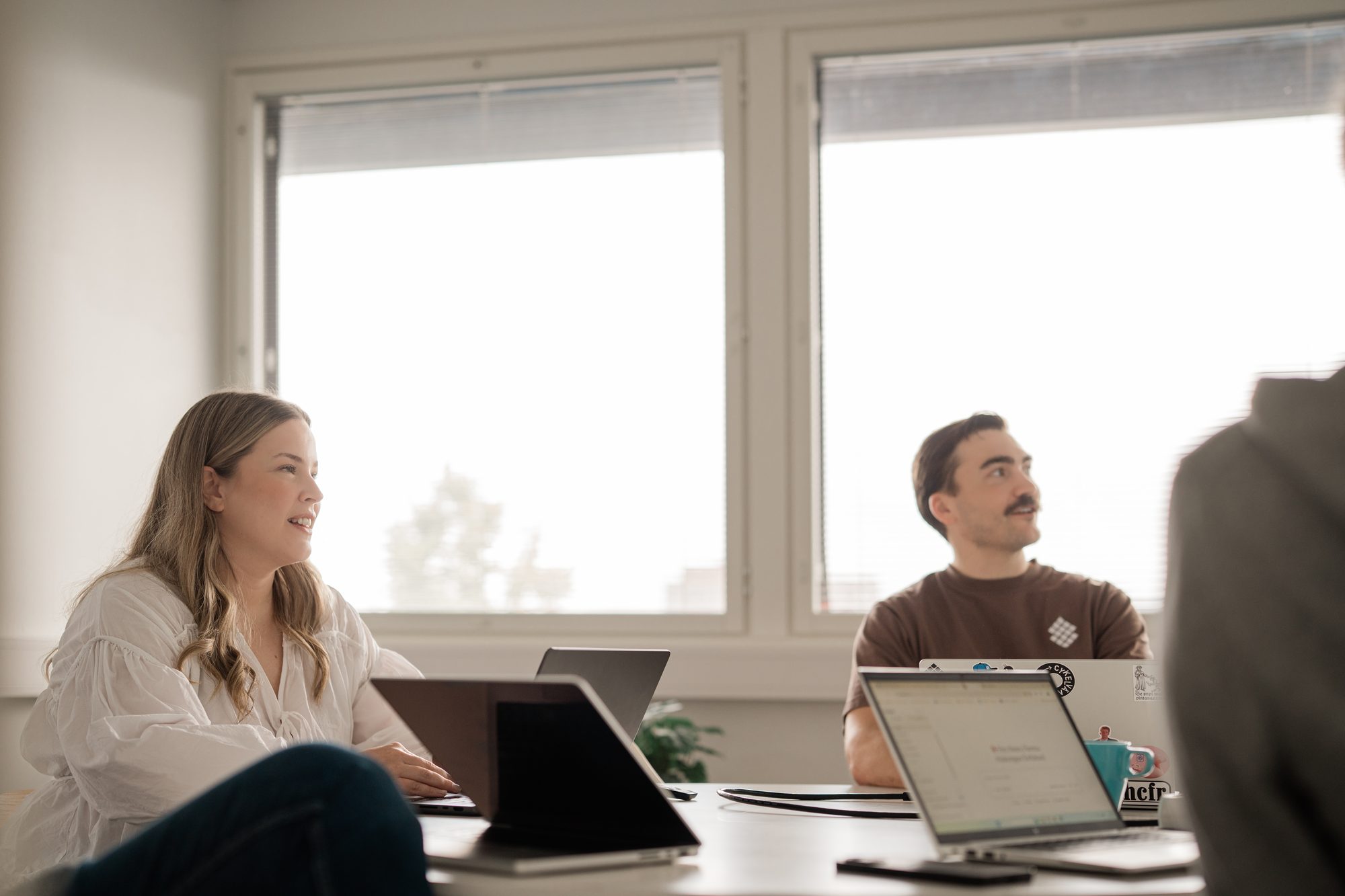 A smiling person in a white blouse following a meeting – Learn by doing: Self-taught Front-end developer