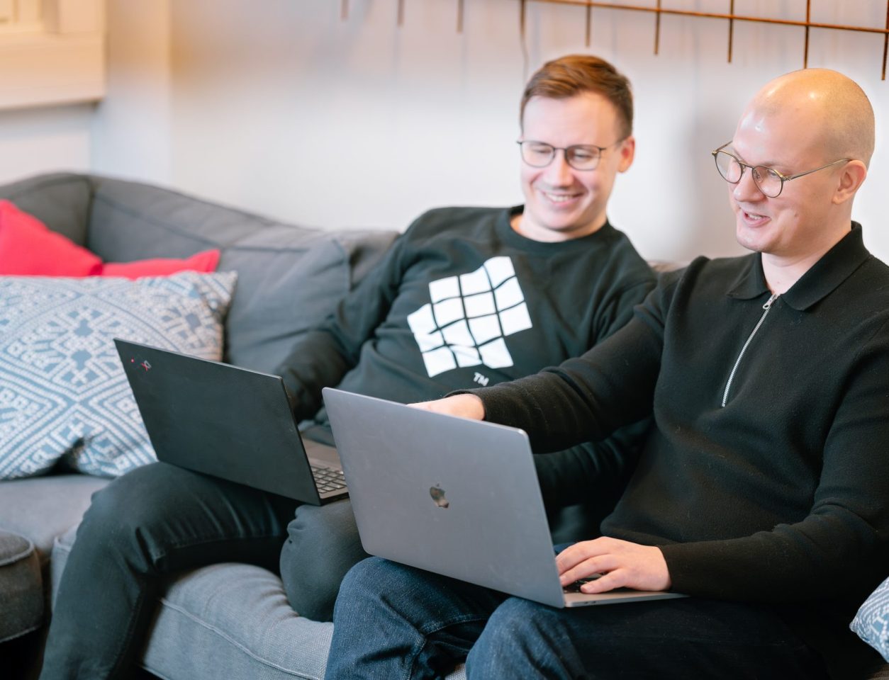 A relaxed work moment on a grey sofa with red and blue cushions – Search engine marketing