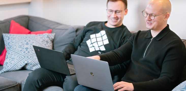 Sofokus-collegepaitainen henkilö katsoo kollegan näyttöä – Varsinais-Suomen Kasvupolku 2015 – Hae mukaan!